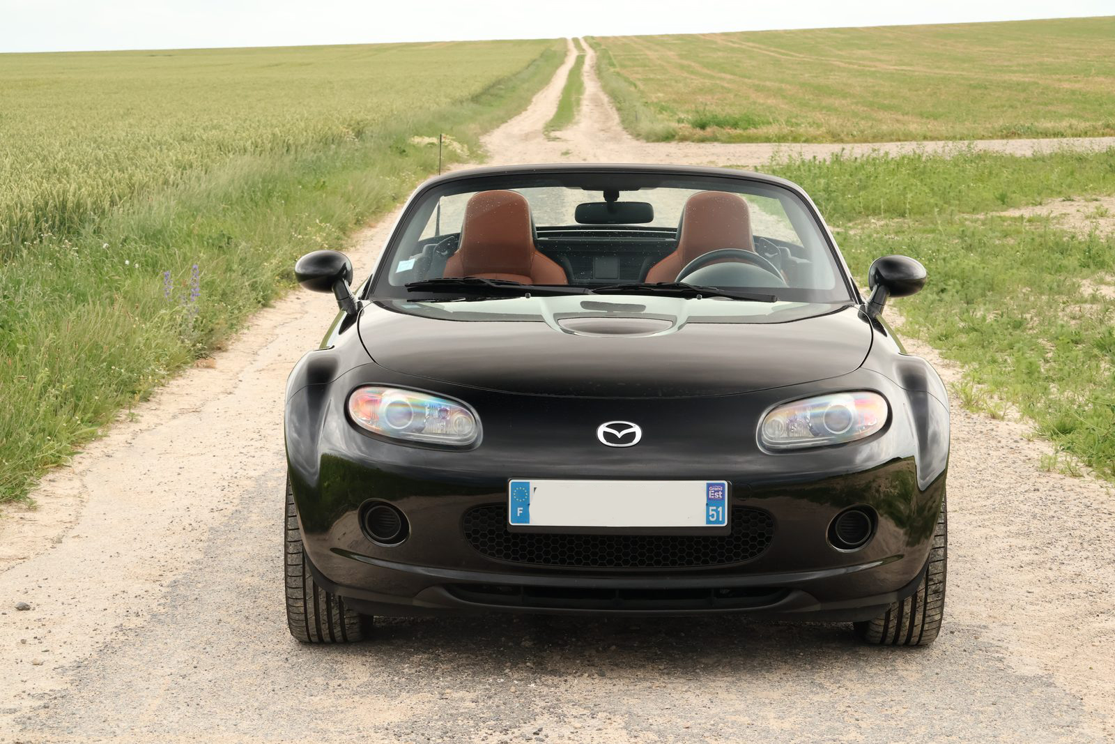 Mazda MX-5 NC noire de face, toit ouvert